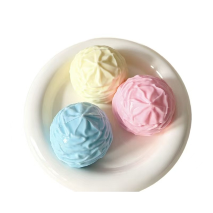 Pastel swirl ice cream squishy balls in blue, vanilla and pink on a white plate